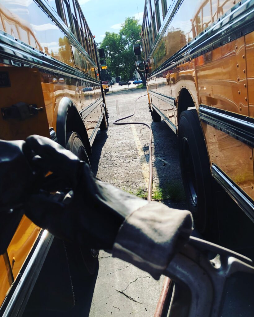 Image of us fleet fueling/wet hosing a school bus