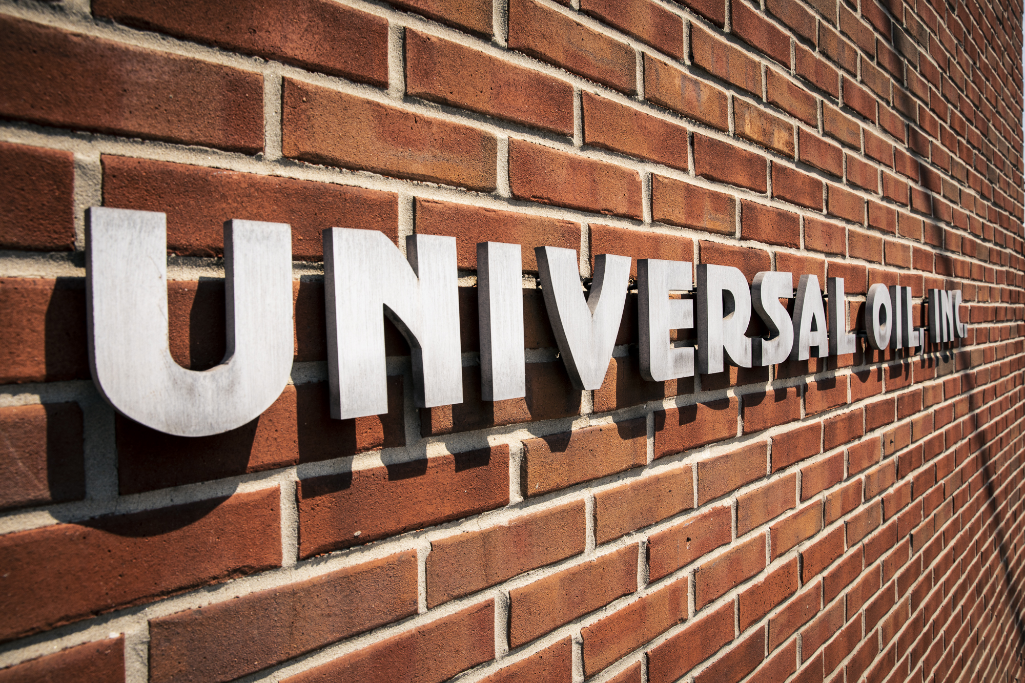 Image of Universal Oil sign hanging on side of our building